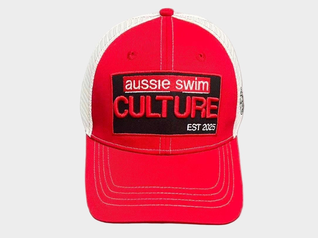 Red cap with 'aussie swim culture' logo on a gray surface
