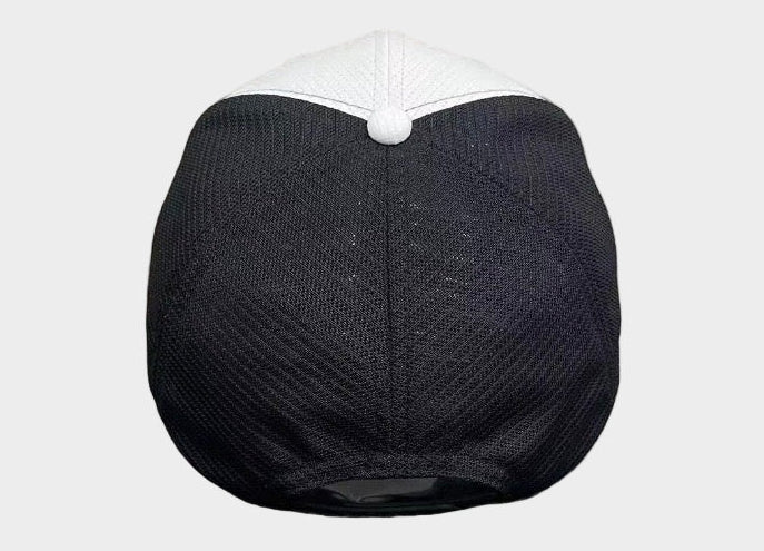 Black cap with white top on a gray surface