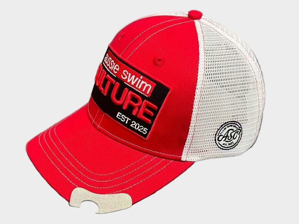 Red and white cap with bottle opener on a gray surface